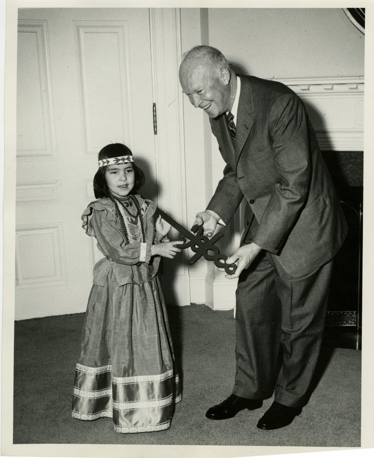 President Eisenhower received the Sword of Hope in connection with the opening of the 1957 Cancer Crusade.  Joyce Dezeller, a 6 year old Indian girl who is a cured cancer victim, presented the Cancer symbol to the President. March 29, 1957 [72-2159-1]