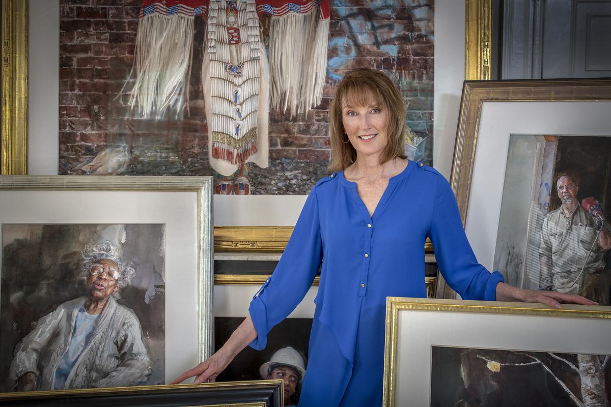 Photo of Artist Mary Whyte with her paintings