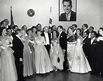 January 20, 1953 - Dwight D. Eisenhower and Mamie Eisenhower pose with guests attending the Inaugural Ball. Left to right: Guy Lombardo (standing behind an unidentified woman), Fred Waring (facing Mrs. Doud), Mrs. John S. Doud, Jeanette MacDonald, Mamie Eisenhower, Dwight D. Eisenhower, Lily Pons, and George Murphy