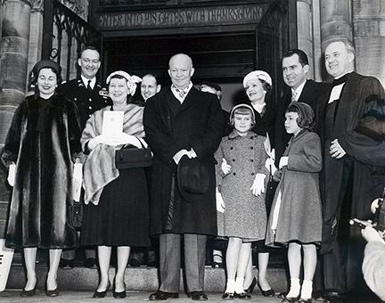 January 20, 1957 - Dwight D. Eisenhower and Richard Nixon leaving the National Presbyterian Church following a pre-inaugural service. The service took place before the private swearing in ceremony. Shown from L to R are: Barbara Eisenhower, John S.D. Eisenhower, Mamie Eisenhower, President Eisenhower, Tricia Nixon, Pat Nixon, Richard Nixon with Julie Nixon standing in front of him, and Reverend Edward Elson [72-2061-5]