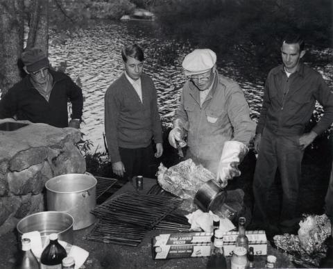 President Eisenhower cooks for friends after a fishing trip, Hianolands Farms, West Greenwich, Rhode Island, September 19, 1958.