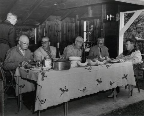 Dwight D. Eisenhower, unknown man, W. Alton Jones, Howard Snyder, and James Hagerty eat dinner. Eisenhower, George Allen, William E. Robinson, James Hagerty, and Howard Snyder were guests of W. Alton Jones at his Hianolands Farms Estate, West Greenwich, Rhode Island. September 19, 1958.