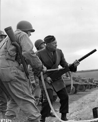 General Eisenhower fires a Browning machine gun during an inspection tour of a U.S. infantry unit at Fort Tregantle, England. February 5, 1944 [65-311]