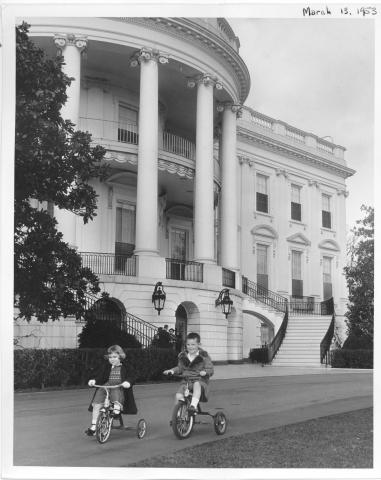 Grandchildren of Dwight D. Eisenhower visit the White House.  They play on the steps and ride their tricycles on the grounds.   Dwight David Eisenhower II, Barbara Anne Eisenhower, and Susan Eisenhower. March 13, 1953 [72-119-2]