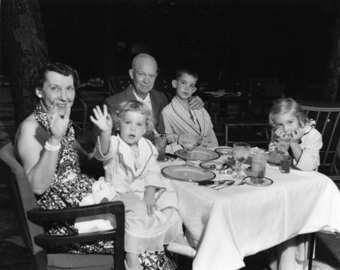 President Dwight D. Eisenhower and Mrs. Mamie Eisenhower spend a weekend vacation at Camp David with their grandchildren. Left to right: Mamie Eisenhower holding Susan, Dwight D. Eisenhower, David, and Anne. July 30-31, 1954. 67-82-A-19.