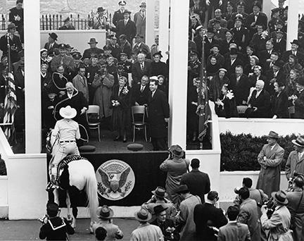 January 20, 1953 - Vice President Nixon (right) and Mamie Eisenhower (center), with big smiles, watch as Dwight D. Eisenhower is lassoed by California cowboy Montie Montana as he passed the Presidential viewing section during the Inaugural Parade