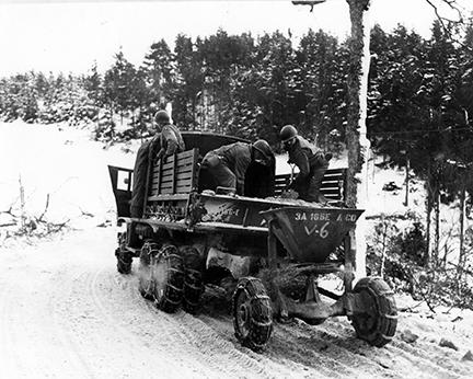 Ardennes-Battle of the Bulge. January 24, 1945 - Members of the 166th Engineers use a mechanical spreader in sanding the snow covered roads near Wiltz, Luxembourg.