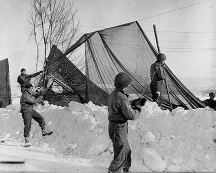 Ardennes-Battle of the Bulge. January 23, 1945 - Restringing "shrimp net" road screen in the Monschau area, Germany, after a violent snow storm brought them down.