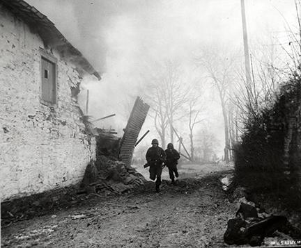 Ardennes-Battle of the Bulge. January 15, 1945 - Infantrymen of the 3rd Armored Division advance under artillery fire in Pont-Le-Ban, Belgium.