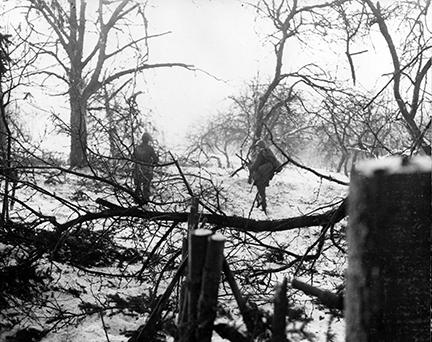 Ardennes-Battle of the Bulge. January 14, 1945 - Two parachute infantrymen advance through a snow-covered wooded section near Henumont, Belgium.