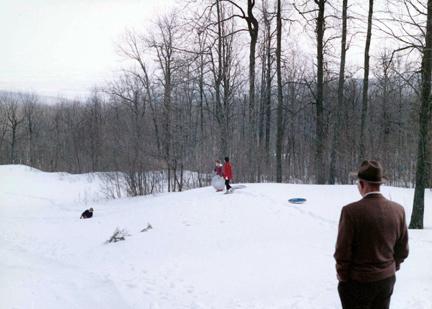March 20, 1960 - Dwight D. Eisenhower watches his grandchildren play in the snow at Camp David.