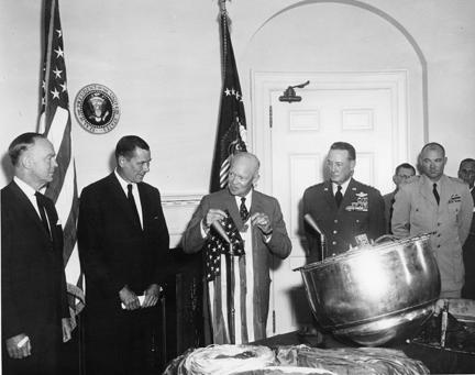 August 15, 1960 - Dwight D. Eisenhower holds the American flag which was carried in the capsule - retrieved from Discoverer XIII. [72-3525-5]