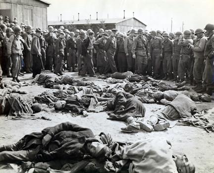 April 12, 1945 - Dwight D. Eisenhower walks around a cluster of bodies of prisoners who were left lying where slain at Ohrdruf