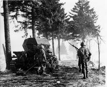 Ardennes-Battle of the Bulge. January 15, 1945 - Infantry supporting Engineers pass a knocked out German tank on their way to front at Compogne, Belgium.