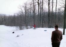 March 20, 1960 - Dwight D. Eisenhower watches his grandchildren play in the snow at Camp David.