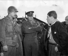 April 12, 1945 - Dwight D. Eisenhower listens as 1st Lt. Alois J. Liethen of Appleton, WI, who served as the interpreter for the tour of Ohrdruf, questions their guide