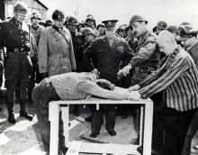 April 12, 1945 - Dwight D. Eisenhower watches as survivors of Ohrdruf demonstrate torture methods used at the camp